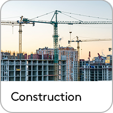 large building being constructed with large cranes in skyline