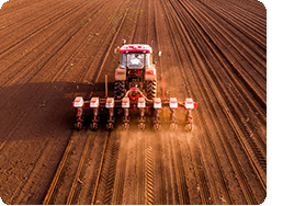 ractor with seed planter creating rows in a dry soil farm land
